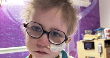Dulcie in hospital bed with tube up her nose.