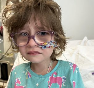 Dulcie looking at the camera upset in a hospital bed