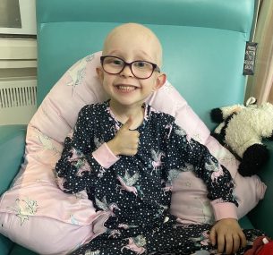 Dulcie smiling at the camera with her thumbs up