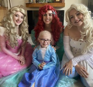 Dulcie dressed as a princess, surrounded by other princesses.