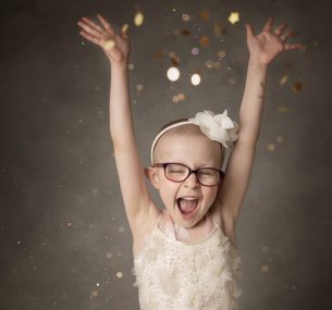 Dulcie cheering at the camera with her hands in the air