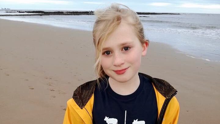 girl in yellow jacket by the beach