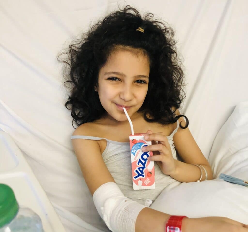 Tia holding a juice carton and smiling at the camera