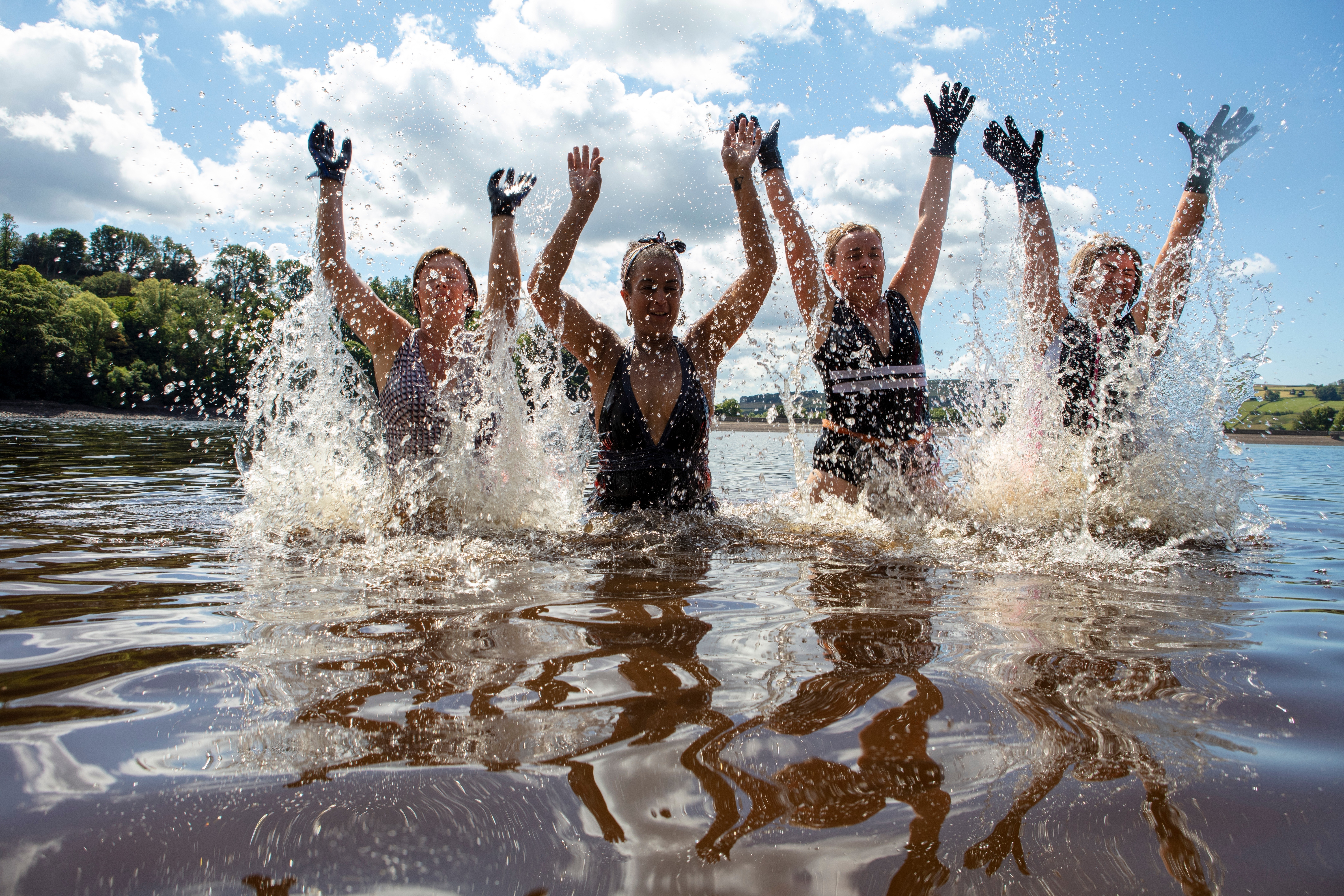 Group of women holding their arms up whilst swimming